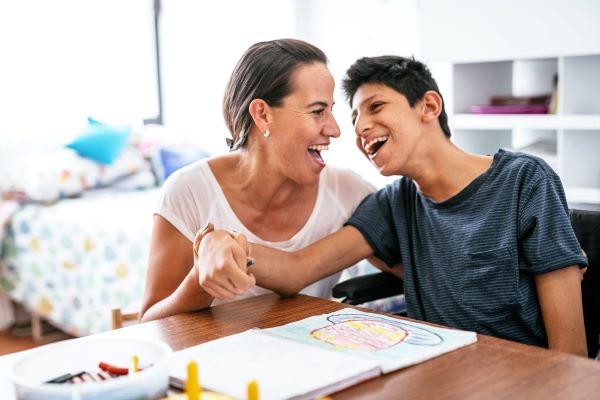 A parent plays at a table with their child