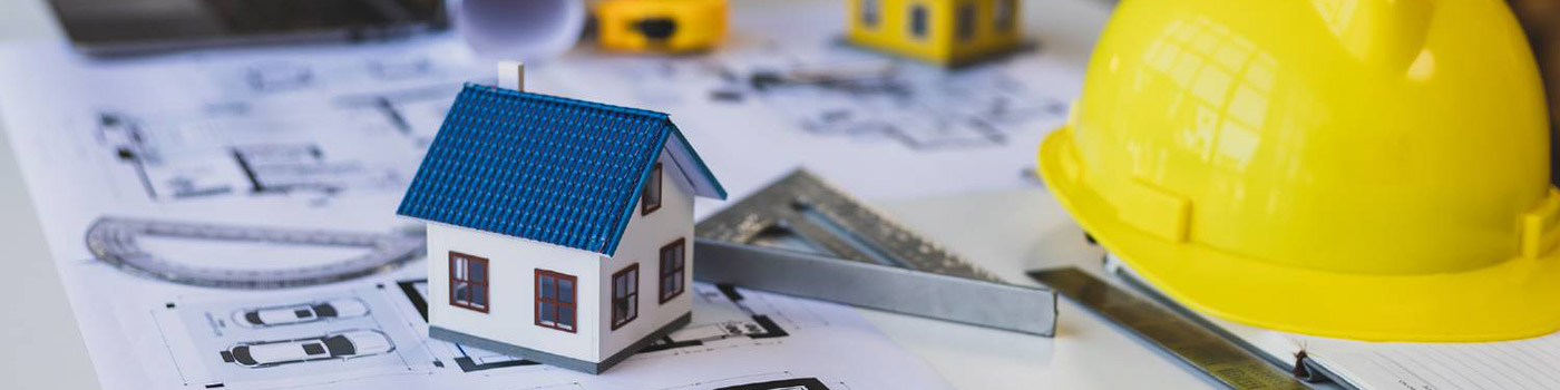 Plans for a housing estate on a table together with a safety hat